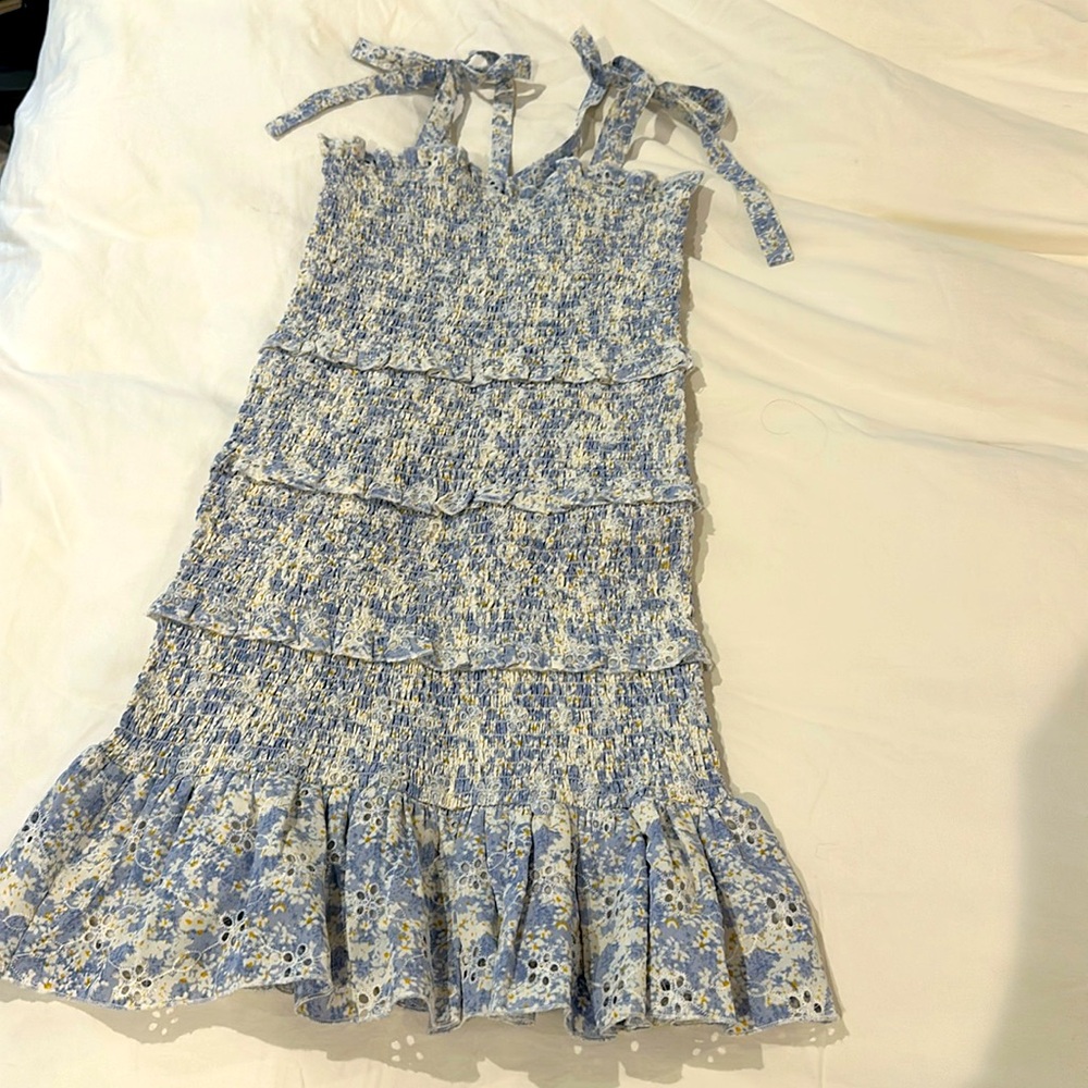 Katie J smocked eyelet sun dress with shoulder ties and ruffled skirt bottom.